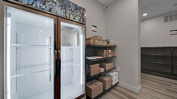 A room with a refrigerator and shelves with boxes on them.
